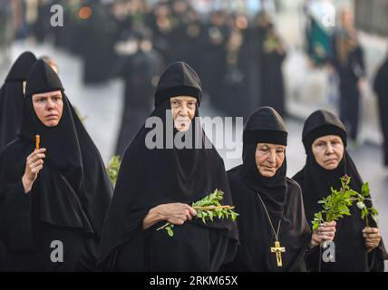 Jerusalem, Israel. 25. August 2023. Eine Gruppe griechisch-orthodoxer Nonnen (russische Nonnen), die Kerzen, Basilikum und Blumen in der Prozession der Ikone der Dormition der Theotokos nach Gethsemane halten. Quelle: Yoram Biberman/Alamy Live News. Stockfoto