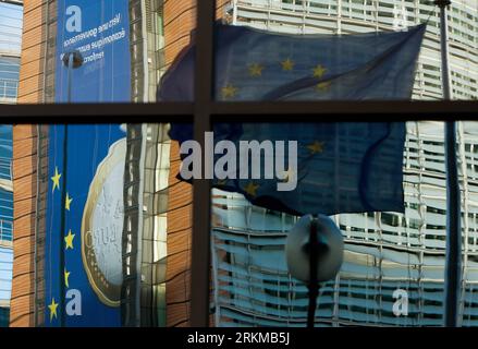 Bildnummer: 56652627  Datum: 06.12.2011  Copyright: imago/Xinhua (111206) -- BRUSSELS, Dec. 6, 2011 (Xinhua) -- The European Union flag and a giant euro banner reflected in the window are pictured outside the European Commission headquarter building in Brussels, capital of Belgium, Dec. 6, 2011. EU leaders will gather during this week s summit in Brussels, struggle to forge an accord on ways to tackle the region s debt crisis. (Xinhua/Zhou Lei)(zl) BELGIUM-EU-EURO PUBLICATIONxNOTxINxCHN Politik EU Gipfel Europa Krise Wirtschaftskrise Finanzkrise Euro Wirtschaft Schuldenkrise Plakate Objekte Im Stock Photo