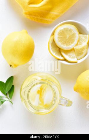 Lemon lemonade in glass pitcher on white background. Top view, flat lay Stockfoto