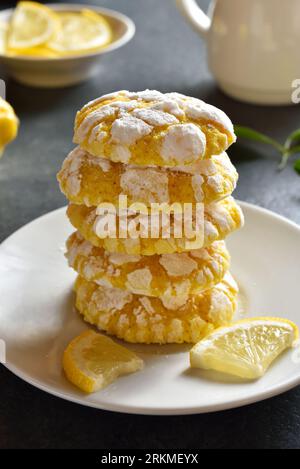 Stack of lemon crinkle cookies on plate over dark stone background. Close up view Stock Photo