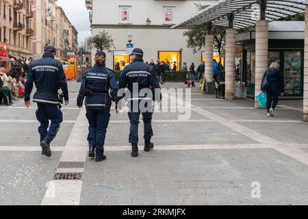 Rückansicht von drei lokalen Polizeibeamten, die im Winter im Stadtzentrum der Küstenstadt Savona, Ligurien, Italien patrouillieren Stockfoto