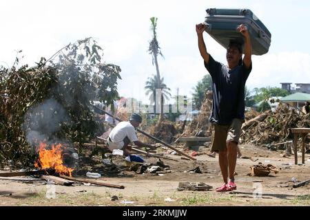 Bildnummer: 56772101  Datum: 21.12.2011  Copyright: imago/Xinhua (111221) -- MANILA, Dec. 21, 2011 (Xinhua) -- A man carries on his head a travel bag found from a damaged house that was damaged by the floods brought by tropical storm Washi in Cagayan de Oro, the Philippines, on Dec. 21, 2011. The Philippine government will release an additional 1 billion pesos (22.77 million U.S. dollars) funding to augment the remaining calamity fund and ensure swift and continuous assistance to the areas hit by storm Washi (local name: Sendong). (Xinhua/Rouelle Umali) (srb) PHILIPPINES--CAGAYAN DE ORO-TROPIC Stock Photo