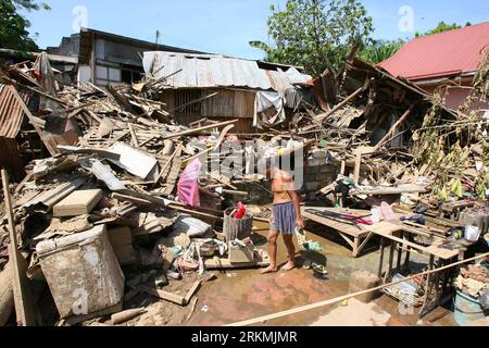 Bildnummer: 56772100  Datum: 21.12.2011  Copyright: imago/Xinhua (111221) -- MANILA, Dec. 21, 2011 (Xinhua) -- A local resident looks for reusable materials through the ruins of a house swept by the floods brought by tropical storm Washi in Cagayan de Oro, the Philippines, on Dec. 21, 2011. The Philippine government will release an additional 1 billion pesos (22.77 million U.S. dollars) funding to augment the remaining calamity fund and ensure swift and continuous assistance to the areas hit by storm Washi (local name: Sendong). (Xinhua/Rouelle Umali) (srb) PHILIPPINES--CAGAYAN DE ORO-TROPICAL Stock Photo