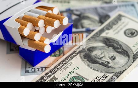 100-Dollar-Banknote mit Tabakzigaretten, Gefahrenlebensweise Stockfoto