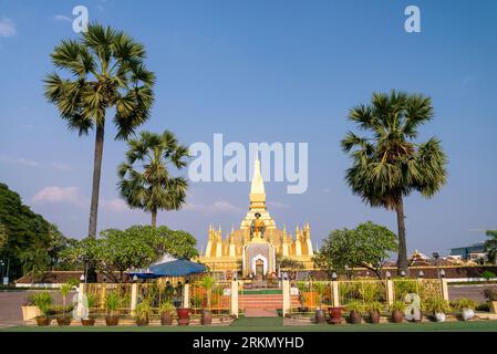 In der Nähe des Eingangs, Statue des alten Königs Setthathirat, die Stupa wurde im 3. Jahrhundert n. Chr. gegründet, leuchtende Goldfarbe im Sonnenlicht Stockfoto