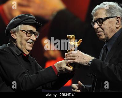 (120218) -- BERLIN, 18. Februar 2012 (Xinhua) -- die italienischen Regisseure Paolo Taviani (R) und Vittorio Taviani für den Film Caesare DEVE Morire ( Caesar Must die ) halten den Goldenen Bären-Preis für den besten Film während der Preisverleihung beim 62. Berlinale Filmfestival in Berlin, Hauptstadt Deutschlands, am 18. Februar 2012. (Xinhua/Ma Ning) (yy) DEUTSCHLAND-BERLINALE FILM FESTIVAL-PREISVERLEIHUNG PUBLICATIONxNOTxINxCHN Stockfoto