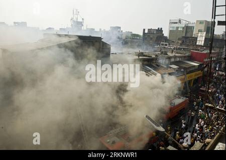 Bildnummer: 57588399  Datum: 22.03.2012  Copyright: imago/Xinhua (120322) -- CALCUTTA, March 22, 2012 (Xinhua) -- Indian bystanders watch while firefighters spray water to control a fire on a building of the Hatibagan market, one of the oldest in Calcutta, capital of eastern Indian state West Bengal, on March, 22, 2012. A large number of shops were destroyed in the fire that broke out on Thursday but no casualties have been reported. (Xinhua/Tumpa Mondal) INDIA-CALCUTTA-FIRE PUBLICATIONxNOTxINxCHN Gesellschaft Feuer Brand Markt Markthalle premiumd xbs x0x 2012 quer      57588399 Date 22 03 201 Stock Photo