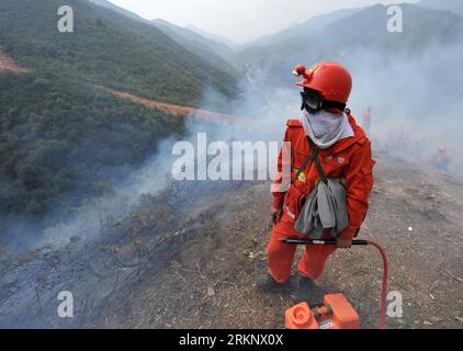 Bildnummer: 57597821  Datum: 22.03.2012  Copyright: imago/Xinhua (120322) -- ANNING, March 22, 2012 (Xinhua) -- A firefighter stands guard on the isolation zone to contain rekindled fire at the Wangjiatan Forest in Anning, a county-level city on the outskirts of Kunming, southwest China s Yunnan Province, March 22, 2012. The fire rekindled near the Jiudu Village on Thursday wee hours. Hundreds of firefighters have been dispatched to extinguish the fire. (Xinhua/Lin Yiguang) (zgp) CHINA-YUNNAN-ANNING-FOREST FIRE-REKINDLE (CN) PUBLICATIONxNOTxINxCHN Gesellschaft Waldbrand Wald Brand Feuerwehr Fe Stock Photo