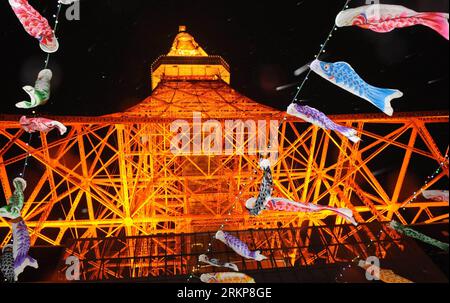 Bildnummer: 57928334  Datum: 24.04.2012  Copyright: imago/Xinhua (120424) -- TOKYO, April 24, 2012 (Xinhua) -- Fish flags are seen flying in front of the illuminated Tokyo Tower in Tokyo, capital of Japan, April 24, 2012. Supply of electricity by Kansai Electric Power Co. and two other utilities in Japan is likely to fall short of maximum demand in August even if businesses and households in their service areas save on power, according to power demand estimates announced by nine electric power companies Monday. (Xinhua/Ma Ping) (msq) JAPAN-SUMMER-POWER PUBLICATIONxNOTxINxCHN Gesellschaft Gebäu Stock Photo