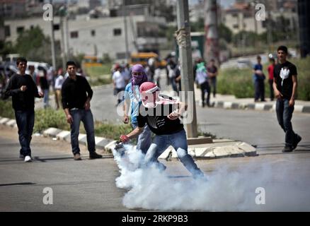 Bildnummer: 57934101 Datum: 26.04.2012 Copyright: imago/Xinhua (120426) -- RAMALLAH, 26. April 2012 (Xinhua) -- ein palästinensischer Demonstrant wirft am 26. April 2012 eine Tränengasgranate auf israelische Soldaten vor dem Ofer-Gefängnis in der Nähe der Westbank-Stadt Ramallah zurück, während eines Protestes in Solidarität mit palästinensischen Gefangenen im Hungerstreik. (Xinhua/Fadi Arouri) (jl) MIDEAST-WEST BANK-PROTEST PUBLICATIONxNOTxINxCHN Gesellschaft Demo Protest Palästina Palästinenser Westjordanland Ausschreitungen xbs x0x 2012 quer Premiumd 57934101 Datum 26 04 2012 Copyright Imago XINHUA Ramallah April 26 2012 X Stockfoto