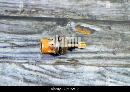 Ein gebrauchter Duschhahn Wasserhahnkörper Kartuschenteile aus Kunststoff und Kupfer, die wegen Wasseraustritt, Rohrleitungen und Wartungsarbeiten befestigt oder ersetzt werden müssen Stockfoto