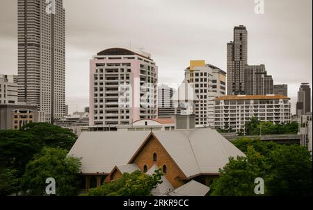 Bangkok, Thailand - 16. Juli 2023 - die christliche Kirche ist umgeben von modernen architektonischen Außengebäuden. Platz für Text, selektiver Fokus. Stockfoto