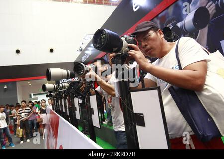 Bildnummer: 58201652  Datum: 06.07.2012  Copyright: imago/Xinhua (120706) -- SHANGHAI, July 6, 2012 (Xinhua) -- Visitors try new Canon cameras at an exhibition in Shanghai, east China s municipality, July 6, 2012. China Shanghai Interphoto and Digital Imaging Exhibition 2012 kicked off in Shanghai World EXPO Exhibition and Convention Center on Friday. The exhibition attracted 185 domestic and overseas exhibitors from 8 countries and regions focusing on photographic and image producing devices, technologies, service and so on. (Xinhua/Pei Xin) (gjh) CHINA-SHANGHAI-PHOTOGRAPHIC-EQUIPMENT-EXHIBIT Stock Photo