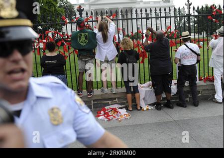 Bildnummer: 58275863 Datum: 24.07.2012 Copyright: imago/Xinhua (120724) -- WASHINGTON D.C., 24. Juli 2012 (Xinhua) -- Demonstranten binden rote Bänder und US-Dollar, während ein Polizist die Medien während der AIDS-Parade in Washington D.C., der Hauptstadt der Vereinigten Staaten, am 24. Juli 2012 vor das Weiße Haus schiebt. Tausende versammelten sich um das Washington Convention Center, wo die 19. Internationale AIDS-Konferenz einberufen wird, und gingen zum Weißen Haus, um den US-Gouverneur um mehr Aufmerksamkeit für die medizinische Versorgung mit AIDS und die Beseitigung der Diskriminierung von HIV-Possitiven zu bitten. (Xinhua/Zhan Stockfoto