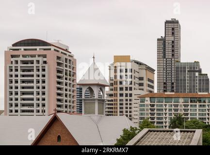 Bangkok, Thailand - 16. Juli 2023 - die christliche Kirche ist umgeben von modernen architektonischen Außengebäuden. Platz für Text, selektiver Fokus. Stockfoto