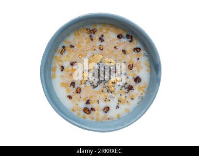 Gesundes, hausgemachtes Malzflocken-Granola besteht aus gerollten Hafer-Cashew-Nüssen, Samen, Chiasamen und Honig in Mandelmilch in Keramikschüssel isoliert auf weiß Stockfoto