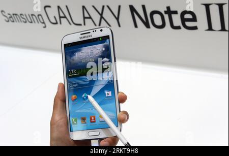 Bildnummer: 58412394  Datum: 31.08.2012  Copyright: imago/Xinhua (120831) -- BERLIN, Aug. 31, 2012 (Xinhua) -- A visitor looks at the Samsung Galaxy Note II smartphone at the Samsung pavilion at the IFA consumer electronics fair in Berlin, Germany, on Aug. 31, 2012. This world s leading trade show for consumer electronics and home appliances will open its door to the public from Aug. 31 till Sept. 5 in the German capital. (Xinhua/Ma Ning) GERMANY-BERLIN-IFA CONSUMER ELECTRONICS FAIR PUBLICATIONxNOTxINxCHN Internationale Funkausstellung Wirtschaft premiumd x0x xds Messe 2012 quer Highlight Stock Photo