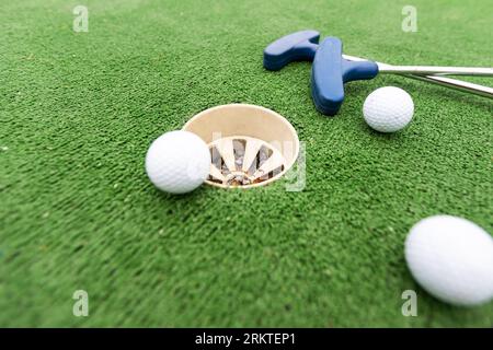 Golfball und Putter sind auf grünem Gras. Stockfoto