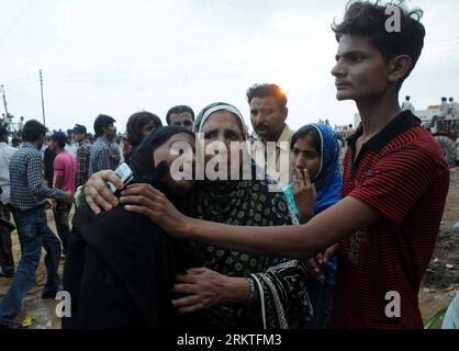 (120913) -- KARACHI, 13. September 2012 (Xinhua) -- Verwandte trauern um den Tod ihrer Lieben vor einer Bekleidungsfabrik nach einem massiven Brand, der am 13. September 2012 in Karachi, Pakistan, zum Tod von 289 Menschen führte. (Xinhua/Masroor) PAKISTAN-KARACHI-FIRE-TRAUER PUBLICATIONxNOTxINxCHN Stockfoto