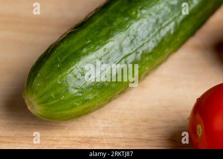 Geschnittene grüne lange Gurke während der Salatzubereitung, Salatzubereitung mit Gemüse in kleine Stücke grüne Gurken geschnitten Stockfoto