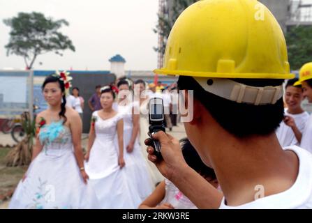 Bildnummer: 58610653 Datum: 19.07.2006 Copyright: imago/Xinhua (121019) -- ZHENGZHOU, 19. Oktober 2012 (Xinhua) -- das Dateifoto, das am 19. Juli 2006 aufgenommen wurde, zeigt einen Bauarbeiter, der ein Foto von der Gruppenhochzeit von Kollegen in der Stadt Jiaozuo in der zentralchinesischen Provinz Henan macht. PUBLICATIONxNOTxINxCHN Gesellschaft Hochzeit Hochzeitsfeier kurios Komik xas x1x 2012 quer o0 Massenhochzeit, 58610653 Datum 19 07 2006 Copyright Imago XINHUA Zhengzhou OCT 19 2012 XINHUA das Aktenfoto vom 19. Juli 2006 zeigt einen Bauarbeiter, der ein Foto von der Hochzeit der Kollegen in Jiaozuo, Stadt Zentral-C, macht Stockfoto