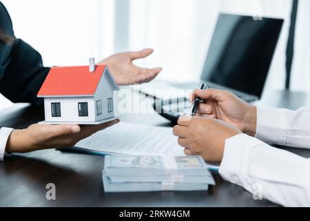 Banken genehmigen Darlehen zum Kauf von Häusern. Immobilienmakler erläutern das Dokument für Kunden, die sich mit ihnen in Verbindung setzen, um ein Haus zu kaufen, Immobilien zu kaufen oder zu verkaufen Stockfoto