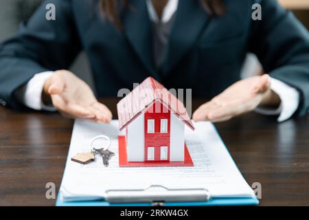 Banken genehmigen Darlehen zum Kauf von Häusern. Immobilienmakler erläutern das Dokument für Kunden, die sich mit ihnen in Verbindung setzen, um ein Haus zu kaufen, Immobilien zu kaufen oder zu verkaufen Stockfoto