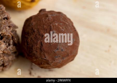 Süße Schokoladenbonbons in Form einer Kugel auf dem Tisch, Schokoladenbonbons zusammen mit anderen Süßigkeiten Stockfoto