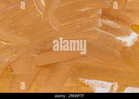 Linien und chaotische Pinselstriche mit goldenen Farben auf Leinwand, abstrakter wunderschöner Hintergrund mit goldenen Schattierungen, die mit Acryl- und Ölfarben bemalt sind Stockfoto