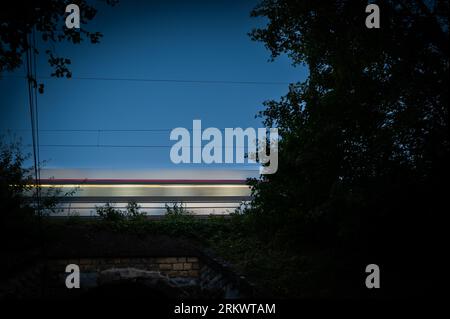 Passenger train on railroad tracks at night Stockfoto