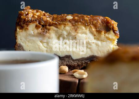 Käsekuchen aus Milchprodukten und Erdnüssen in Karamell, köstliches Dessert mit Erdnüssen, die in Stücke geschnitten werden, um in einem Café Tee zu machen Stockfoto