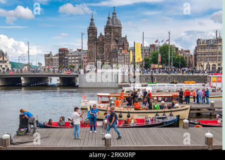 Amsterdam, Holland - 17. Juli 2023: Das tägliche Leben in Amsterdam und die Basilika des Heiligen Nikolaus im Hintergrund. Stockfoto