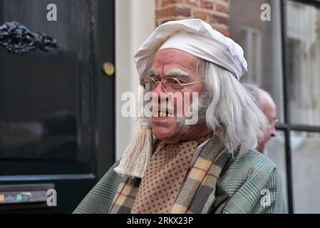 Schauspieler mit weißem Hut, langen grauen Haaren und gelblichen Zähnen während des Dickens Feast in Deventer Stockfoto