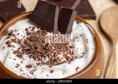 Joghurt aus Sahne mit Schokoladenstücken und Krümeln, hausgemachter Joghurt aus Milchprodukten mit Milchschokolade Stockfoto