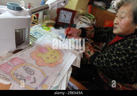 Bildnummer: 58883548  Datum: 05.12.2012  Copyright: imago/Xinhua Qu Jinshou designs the patterns for sweater at home in Xujing Town, east China s Shanghai Municipality, Dec. 5, 2012. The 83-year-old Qu has been making hand-woven sweaters for children in impoverished regions using her own savings for 16 years. Having sent over 400 sweaters to children in needy areas, Qu became the kindly Sweater Granny in children s hearts. (Xinhua/Pei Xin) (zz) CHINA-SHANGHAI-SWEATER GRANNY(CN) PUBLICATIONxNOTxINxCHN Gesellschaft Handarbeit Stricken x0x xdd 2012 quer     58883548 Date 05 12 2012 Copyright Imag Stock Photo