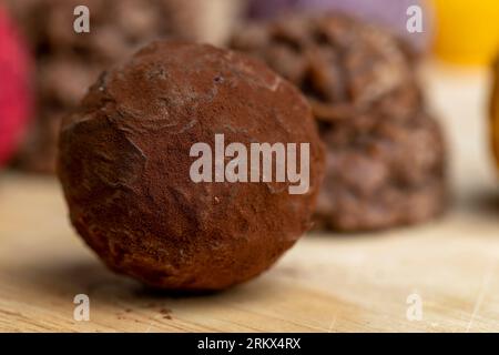 Süße Schokoladenbonbons in Form einer Kugel auf dem Tisch, Schokoladenbonbons zusammen mit anderen Süßigkeiten Stockfoto