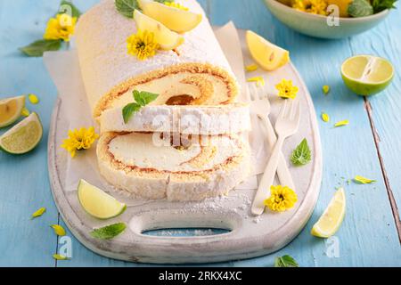 Süße Mangoroulade serviert als Sommerdessert. Schweizer Brötchen mit Zucker und Zitrusfrüchten. Stockfoto