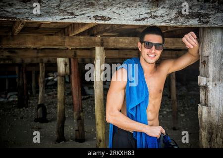 Foto eines Mannes, der mit einem Handtuch um den Hals posiert Stockfoto