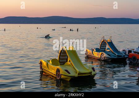 Bunte Paddelboote lustige Aktivität im Sonnenuntergang mit einer Rutsche auf dem Balaton in Ungarn. Stockfoto