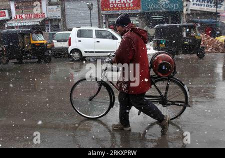 Bildnummer: 59055239  Datum: 12.01.2013  Copyright: imago/Xinhua (130112) -- SRINAGAR, Jan. 12, 2013 (Xinhua) -- A Kashmiri man walk with his bicycle during a snowfall in Srinagar, summer capital of Indian-controlled Kashmir, Jan. 13, 2012. Fresh snowfall intensify the cold wave here, forcing the closure of Srinagar-Jammu National highway, the road that connects Indian-controlled Kashmir with the rest of India.(Xinhua/Javed Dar) (srb) KASHMIR-SRINAGAR-SNOWFALL PUBLICATIONxNOTxINxCHN Gesellschaft Winter Gasflasche x0x xds 2013 quer      59055239 Date 12 01 2013 Copyright Imago XINHUA  Srinagar Stock Photo