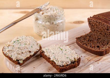 Roggenbrotscheiben mit herrlicher Mischung aus Pastete, Eiern und Schnittlauch sorgen für eine köstliche Präsentation auf hölzernem Hintergrund Stockfoto