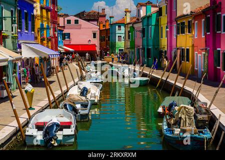 BURANO, ITALIEN - 24. JUNI 2022: Farbenfrohe Gebäude und Geschäfte auf der kleinen Insel Burano in der venezianischen Lagune in der Nähe der Stadt Venedig Stockfoto