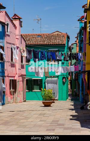 BURANO, ITALIEN - 24. JUNI 2022: Farbenfrohe Gebäude und Geschäfte auf der kleinen Insel Burano in der venezianischen Lagune in der Nähe der Stadt Venedig Stockfoto