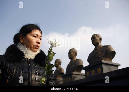 Bildnummer: 59103137  Datum: 18.01.2013  Copyright: imago/Xinhua A woman with a white chrysanthenum in her hands mourns three late fire fighters during a memorial event at Xiaoshan District in Hangzhou, capital of east China s Zhejiang Province, Jan. 18, 2013. The unveiling ceremony of statues of the three firefighters Yin Jinliang, Chen Wei and Yin Zhihui, who have sacrificed while putting out a fire in Xiaoshan  was held here on Friday. More than 500 attended the ceremony. (Xinhua/Cui Xinyu) (wjq) CHINA-ZHEJIANG-HANGZHOU-FIRE FIGHTERS-STATUE-UNVEILING CEREMONY (CN) PUBLICATIONxNOTxINxCHN Ges Stock Photo