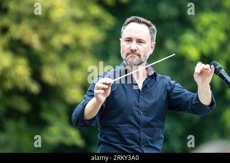 26. August 2023, Brandenburg, Cottbus: Im Rahmen eines Mitspielkonzerts zur Eröffnung der neuen Saison des Cottbuser Staatstheaters dirigiert Generalmusikdirektor Alexander Merzyn Amateurmusiker. "Zusammen. Hier.“ So lautet das Motto des Cottbuser Staatstheaters für die Spielzeit 2023/24, die das Brandenburgische Vierspänner-Theater an diesem Wochenende gemeinsam mit Bürgern feiert. Insgesamt werden 19 Premieren in den Bereichen Theater, Musiktheater und Ballett, acht philharmonische Konzerte und zahlreiche Veranstaltungen in den Serien „Special Format“ und „Special“ erlebt. Foto: Frank Hammerschmidt/dpa/ Stockfoto