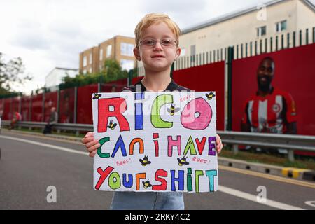 26. August 2023; Gtech Community Stadium, Brentford, London, England; Premier League Football, Brentford versus Crystal Palace; Young Brentford Fan Freddie hält ein Schild hoch und bittet um das Trikot von Rico Henry of Brentford vor dem Gtech Community Stadium Credit: Action Plus Sports Images/Alamy Live News Stockfoto