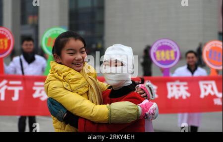 130127 -- HEFEI, Jan. 27, 2013 Xinhua -- A passerby hugs with a a staff member dressed like a leprosy patient with bandage on the square of the Hefei Railway Station in Hefei, capital of east China s Anhui Province, Jan. 27, 2013. Staff members from a local center for disease control and prevention carried out a campaign to promote leprosy prevention here on Sunday, the 60th World Leprosy Day. Xinhua/Liu Junxi xzj CHINA-ANHUI-HEFEI-LEPROSY PREVENTION CN PUBLICATIONxNOTxINxCHN Stock Photo