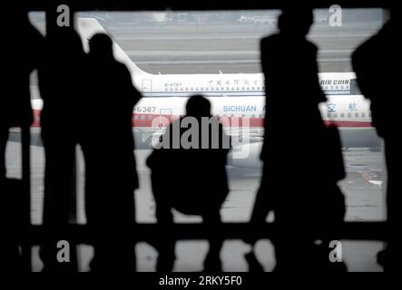 Bildnummer: 59150275  Datum: 30.01.2013  Copyright: imago/Xinhua (130130) -- BEIJING, Jan. 30, 2013 (Xinhua) -- File photo taken on Jan. 20, 2012 shows passengers look out of the departure terminal windows as they wait to board a plane at Chengdu Shuangliu International Airport in Chengdu, capital of southwest China s Sichuan Province. China s transportation system has to undergo a challenge during every Spring Festival holidays, which sees a huge number of take to the roads for family reunions. To have reunion dinner with their families on Chinese New Year s Eve, those who have worked or stud Stock Photo