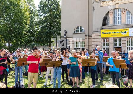 26. August 2023, Brandenburg, Cottbus: Bei einem Mitspielkonzert anlässlich der Eröffnungsveranstaltung des Cottbuser Staatstheaters zur neuen Saison unterhalten Amateurmusiker die Besucher. "Zusammen. Hier.“ So lautet das Motto des Cottbuser Staatstheaters für die Spielzeit 2023/24, die das brandenburgische Vierfachtheater an diesem Wochenende gemeinsam mit Bürgern feiert. Insgesamt werden 19 Premieren in den Bereichen Theater, Musiktheater und Ballett, acht philharmonische Konzerte und zahlreiche Veranstaltungen in den Serien „Special Format“ und „Special“ erlebt. Foto: Frank Hammerschmidt/dpa Stockfoto