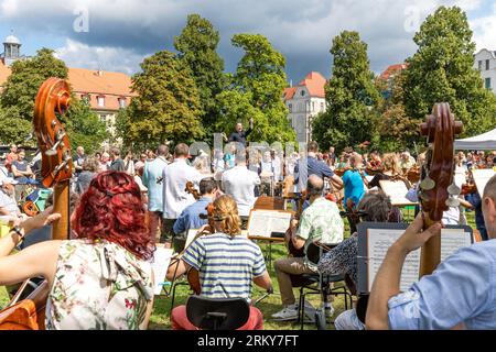 26. August 2023, Brandenburg, Cottbus: Bei einem Mitspielkonzert anlässlich der Eröffnungsveranstaltung des Cottbuser Staatstheaters zur neuen Saison unterhalten Amateurmusiker die Besucher. "Zusammen. Hier.“ So lautet das Motto des Cottbuser Staatstheaters für die Spielzeit 2023/24, die das brandenburgische Vierfachtheater an diesem Wochenende gemeinsam mit Bürgern feiert. Insgesamt werden 19 Premieren in den Bereichen Theater, Musiktheater und Ballett, acht philharmonische Konzerte und zahlreiche Veranstaltungen in den Serien „Special Format“ und „Special“ erlebt. Foto: Frank Hammerschmidt/dpa Stockfoto